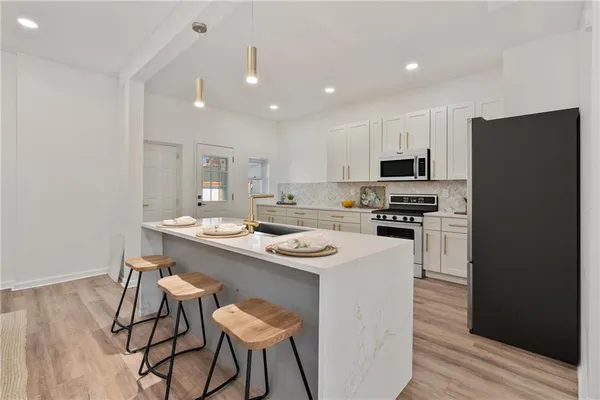 a kitchen with a sink a microwave a refrigerator and cabinets