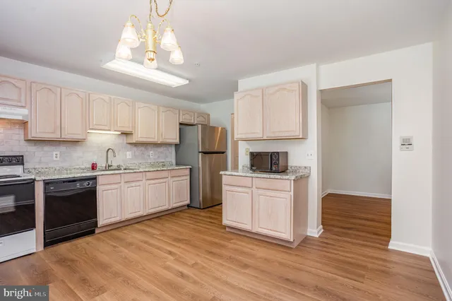 a kitchen with granite countertop white cabinets and stainless steel appliances