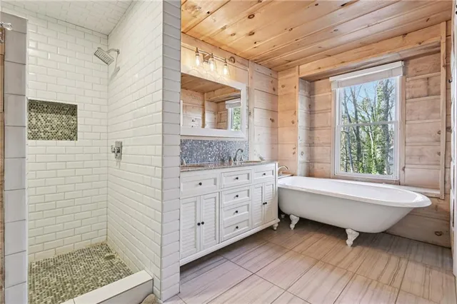 a spacious bathroom with a double vanity sink a mirror and a bathtub