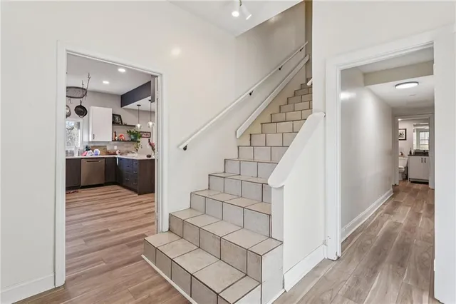 a view of a hallway with wooden floor and staircase