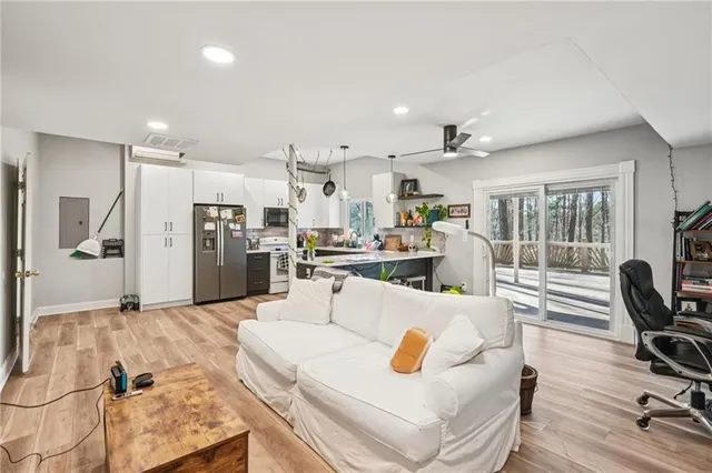 a living room with stainless steel appliances kitchen island granite countertop furniture and a view of kitchen