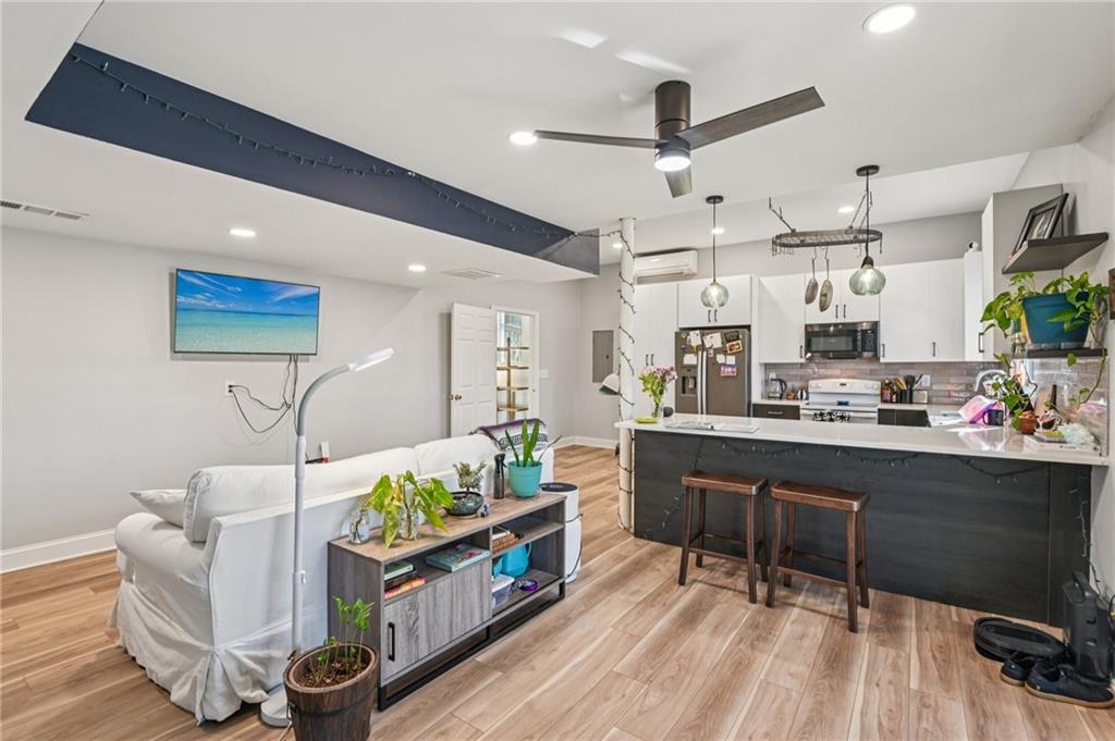 9485 Martin Road Roswell, GA 30076 - Photo 20 of 33 a kitchen with stainless steel appliances kitchen island granite countertop a table chairs in it and wooden floors
