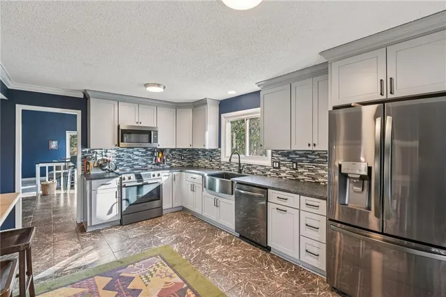 a kitchen with stainless steel appliances granite countertop a refrigerator stove and sink