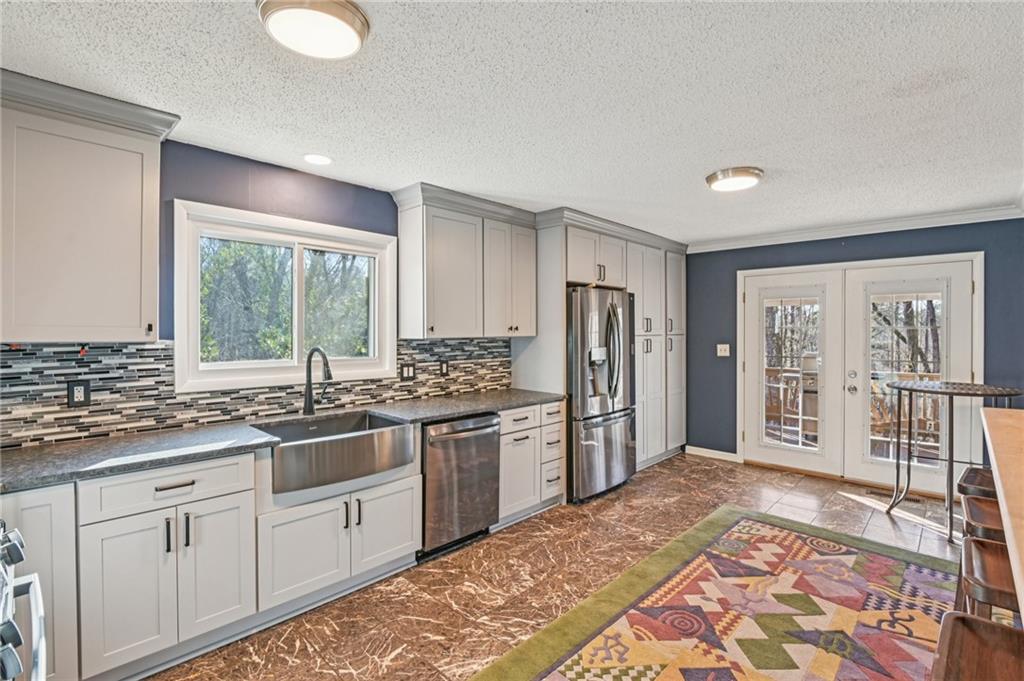 9485 Martin Road Roswell, GA 30076 - Photo 7 of 33 a kitchen with stainless steel appliances granite countertop a sink stove and refrigerator