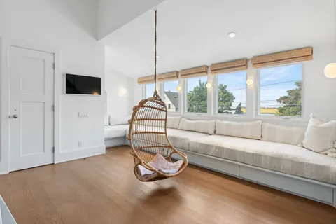 a living room with furniture a flat screen tv and a large window