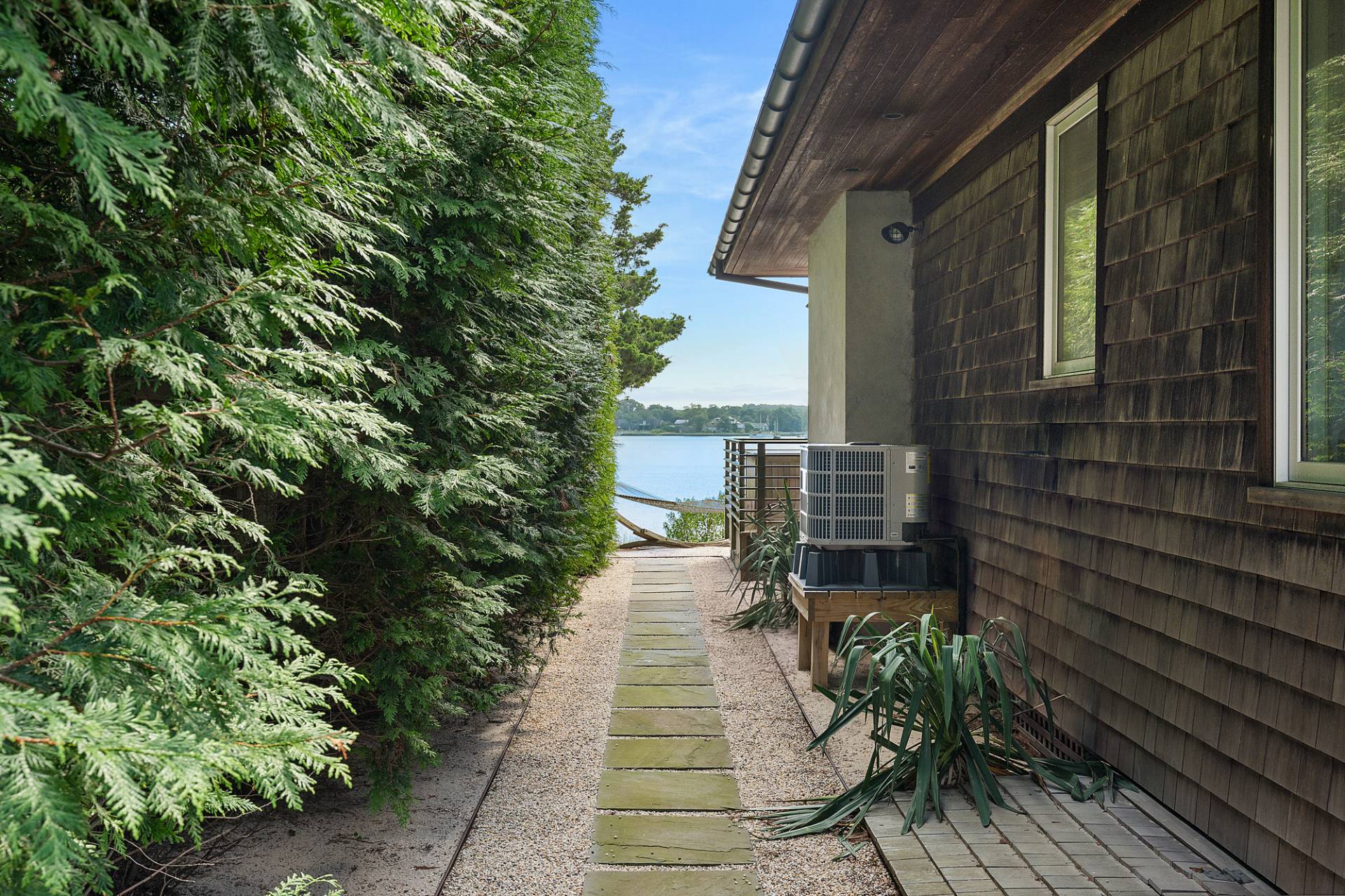 210 Towd Point Road Southampton, NY 11968 - Photo 14 of 21 a view of a pathway with a chair and table in the back yard of the house