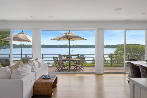 a living room with furniture and floor to ceiling windows
