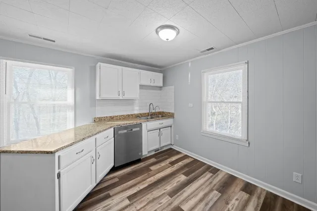 a kitchen with granite countertop white cabinets and white appliances