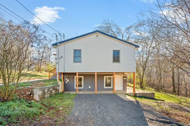 a view of a house with a yard and tree s