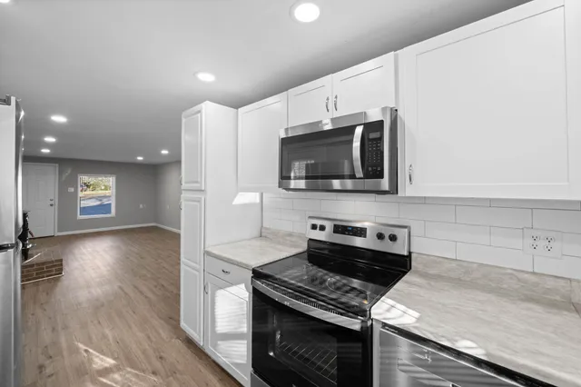 a view of a room with wooden floor and white walls