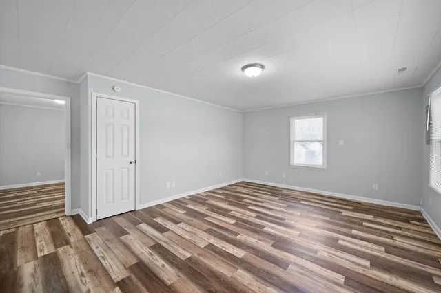 a view of a bedroom with a bed and wooden floor