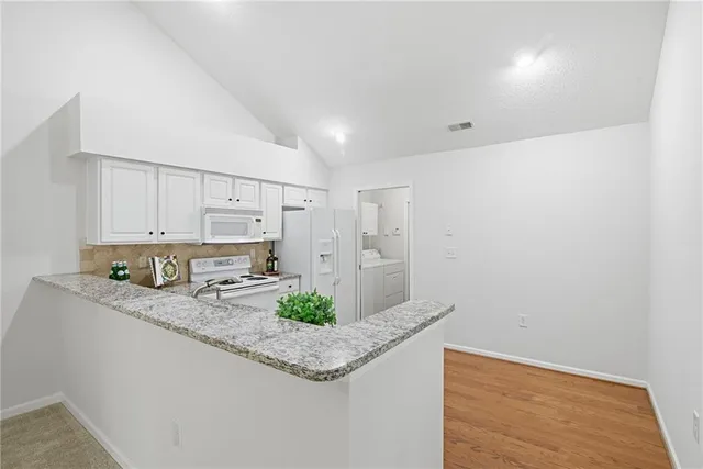 a kitchen with stainless steel appliances granite countertop a sink a stove and a refrigerator