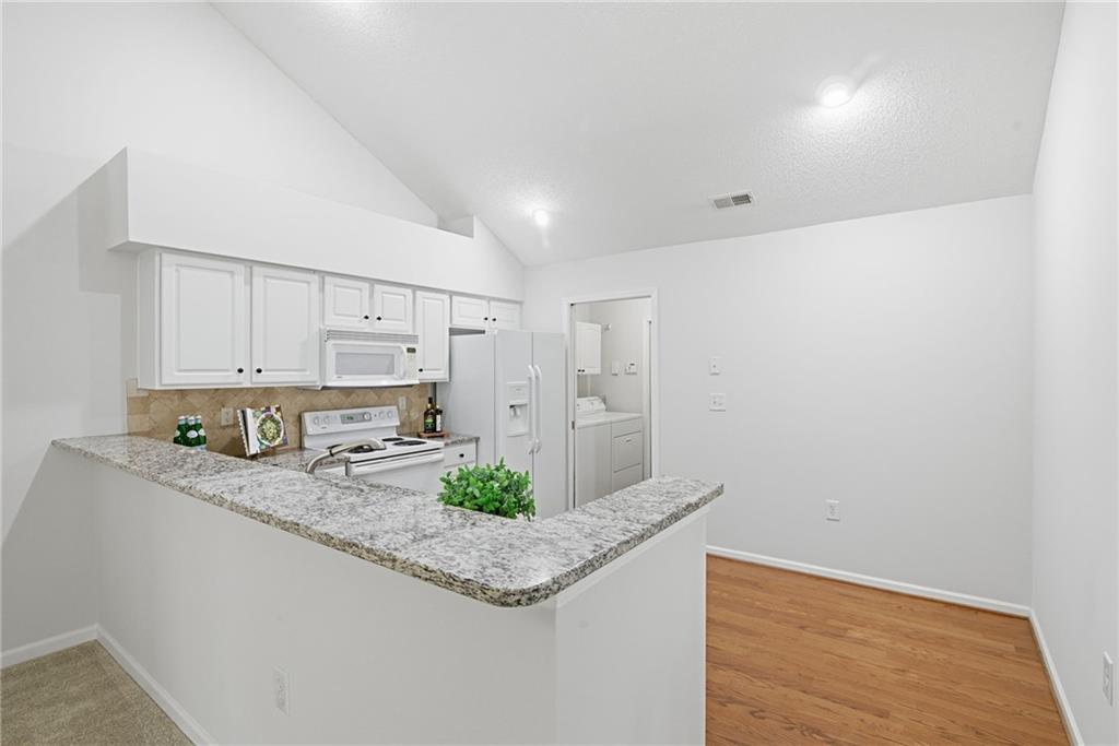 34102 Harvest Ridge Lane, Unit 34 Alpharetta, GA 30022 - Photo 11 of 31 a kitchen with stainless steel appliances granite countertop a sink a stove and a refrigerator