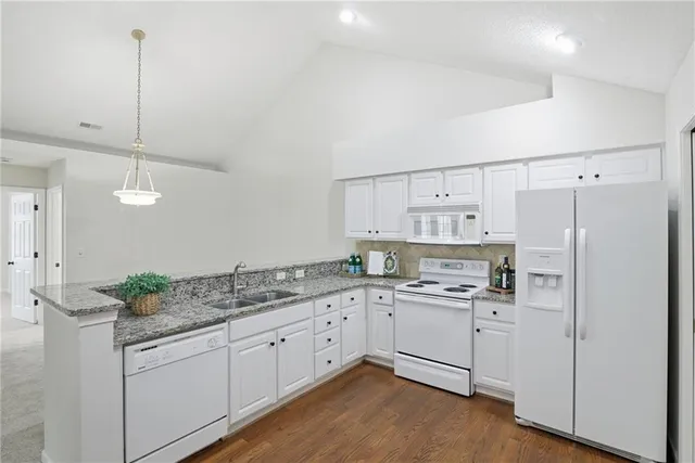 a kitchen with a sink dishwasher and white cabinets