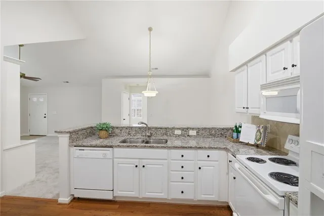 a kitchen with granite countertop a sink stove and cabinets
