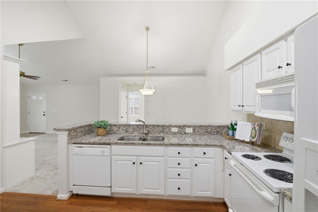34102 Harvest Ridge Lane, Unit 34 Alpharetta, GA 30022 - Photo 13 of 31 a kitchen with granite countertop a sink stove and cabinets