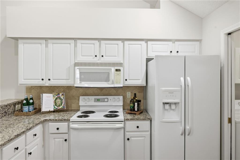 34102 Harvest Ridge Lane, Unit 34 Alpharetta, GA 30022 - Photo 14 of 31 a kitchen with a refrigerator a stove a sink and cabinets