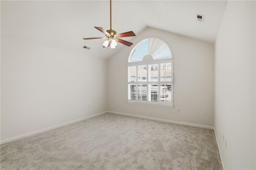 34102 Harvest Ridge Lane, Unit 34 Alpharetta, GA 30022 - Photo 19 of 31 an empty room with a chandelier fan and windows