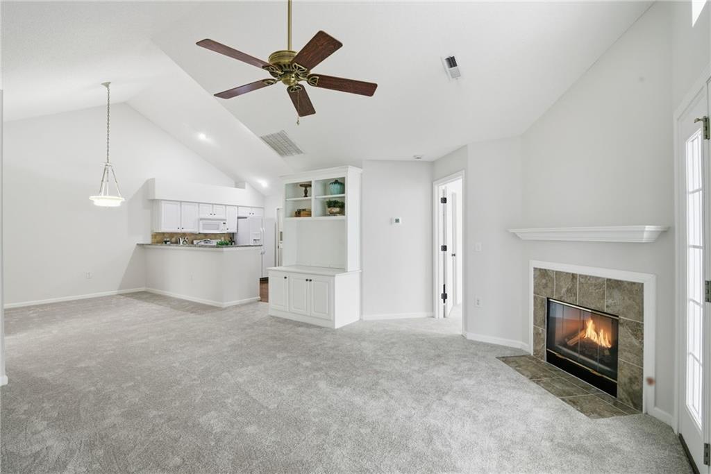 34102 Harvest Ridge Lane, Unit 34 Alpharetta, GA 30022 - Photo 3 of 31 a view of a livingroom with a fireplace a ceiling fan a fireplace and windows