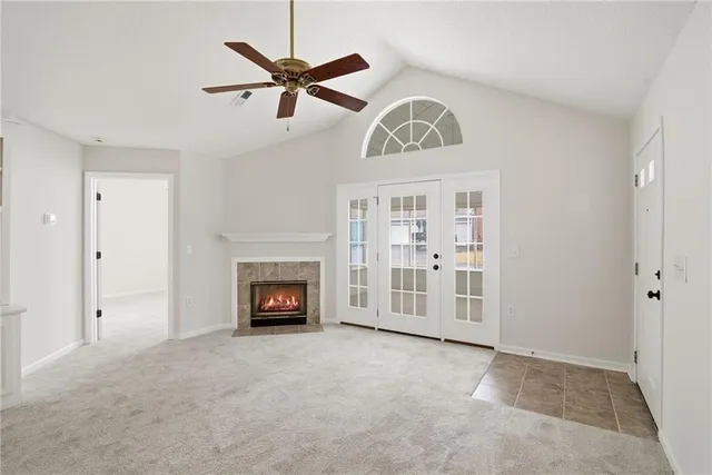 a view of a livingroom with a fireplace a ceiling fan and a wooden floor
