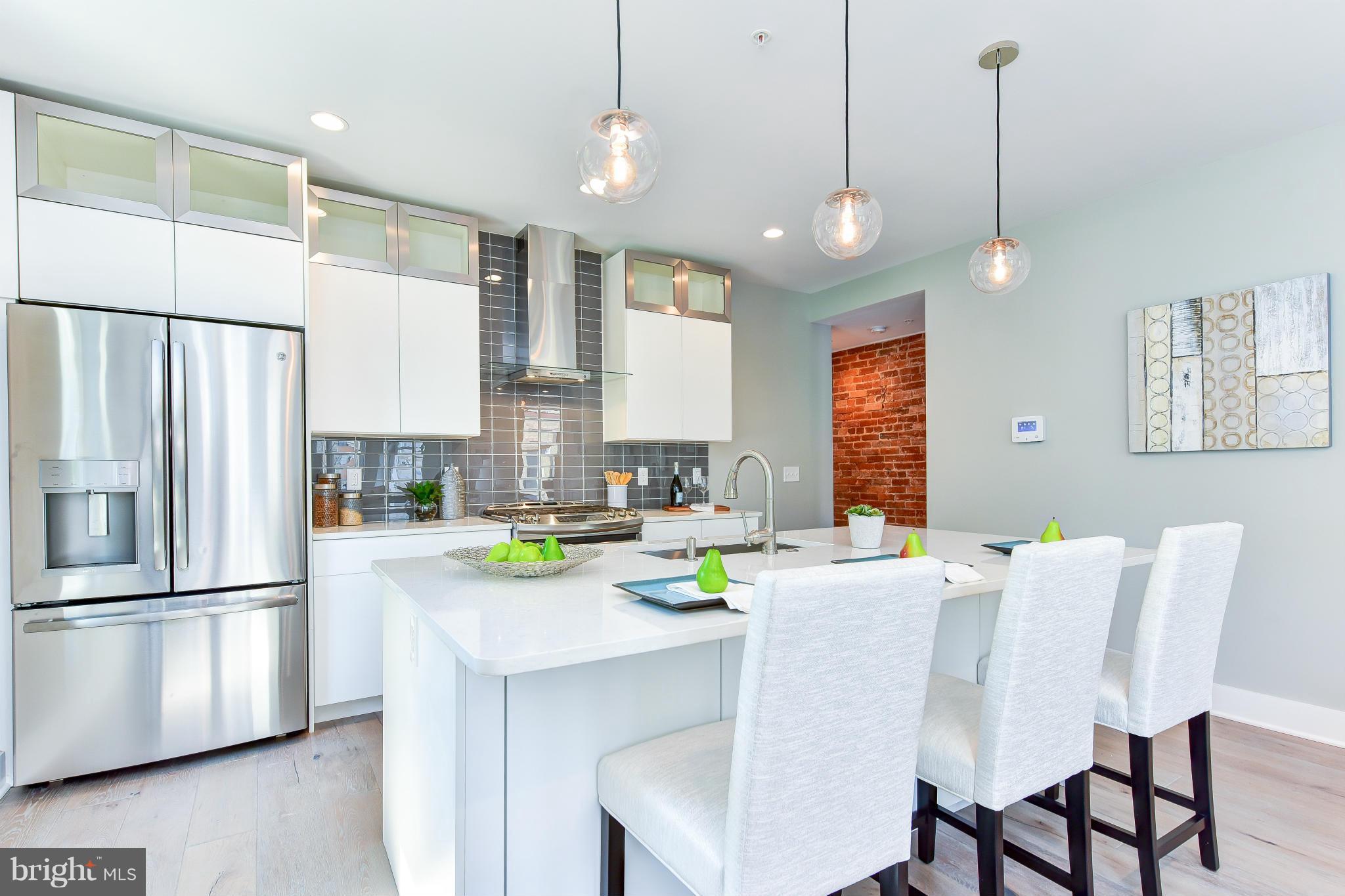 37 Todd Place Northeast, Unit 2 Washington, DC 20002 - Photo 7 of 21 a kitchen with a table chairs refrigerator and microwave