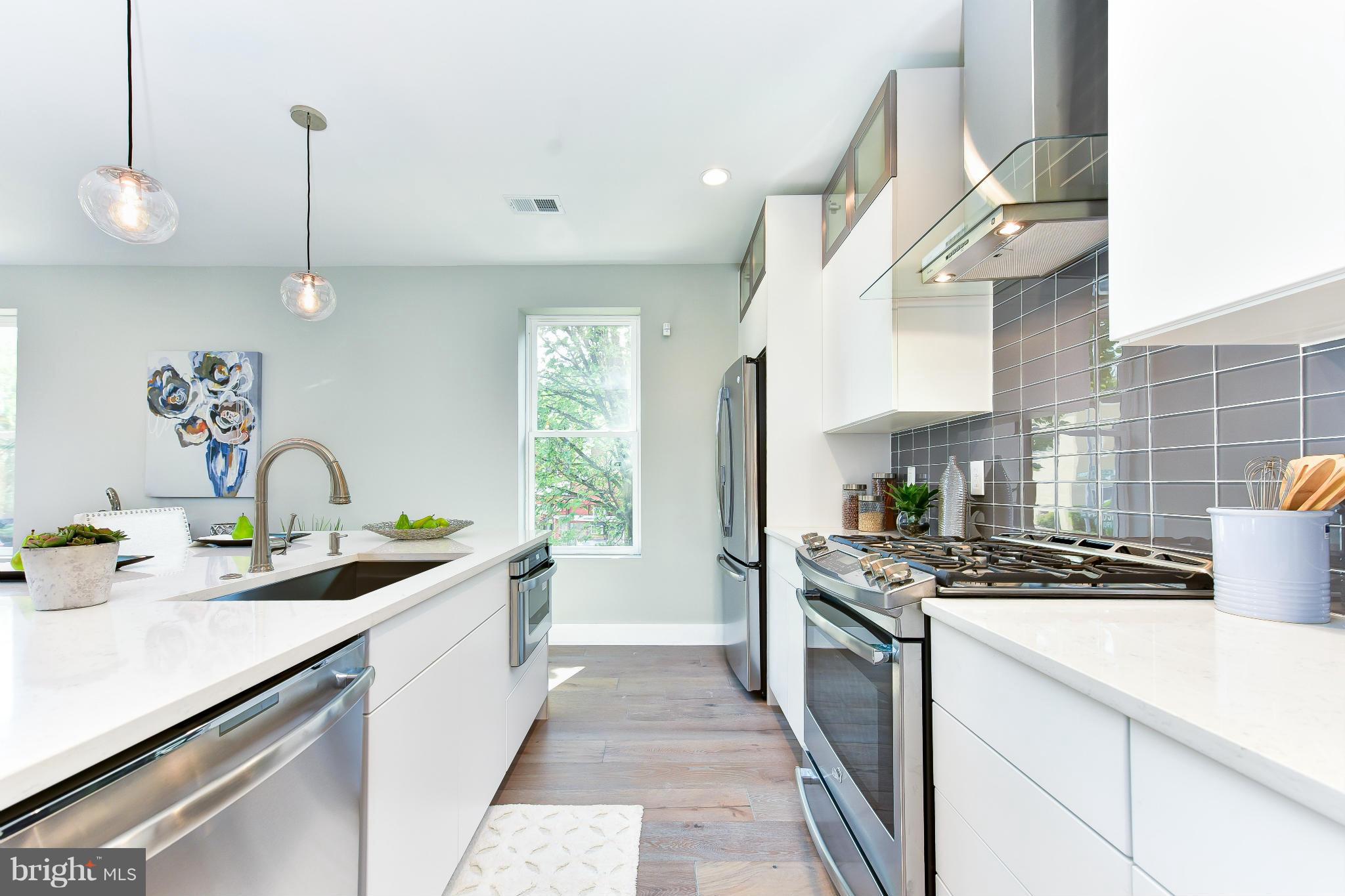 37 Todd Place Northeast, Unit 2 Washington, DC 20002 - Photo 10 of 21 a kitchen with stainless steel appliances a sink a stove and a wooden floors