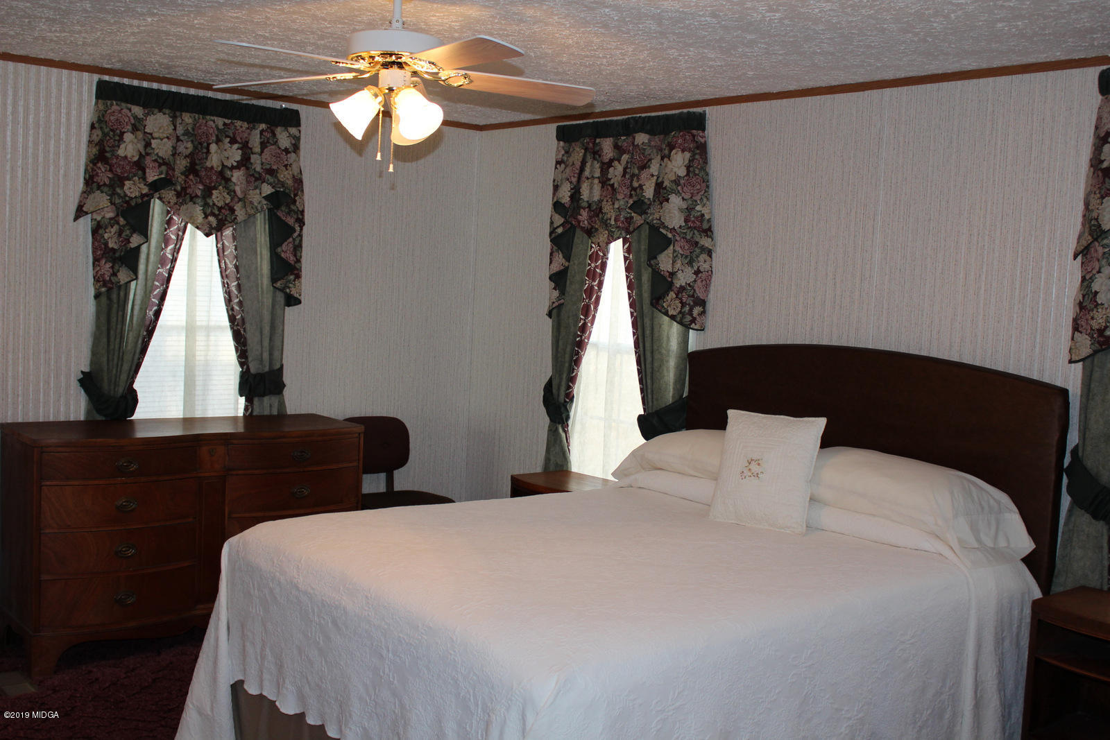 10094 Zebulon Road Forsyth, GA 31029 - Photo 11 of 20 a bedroom with a bed and a chandelier