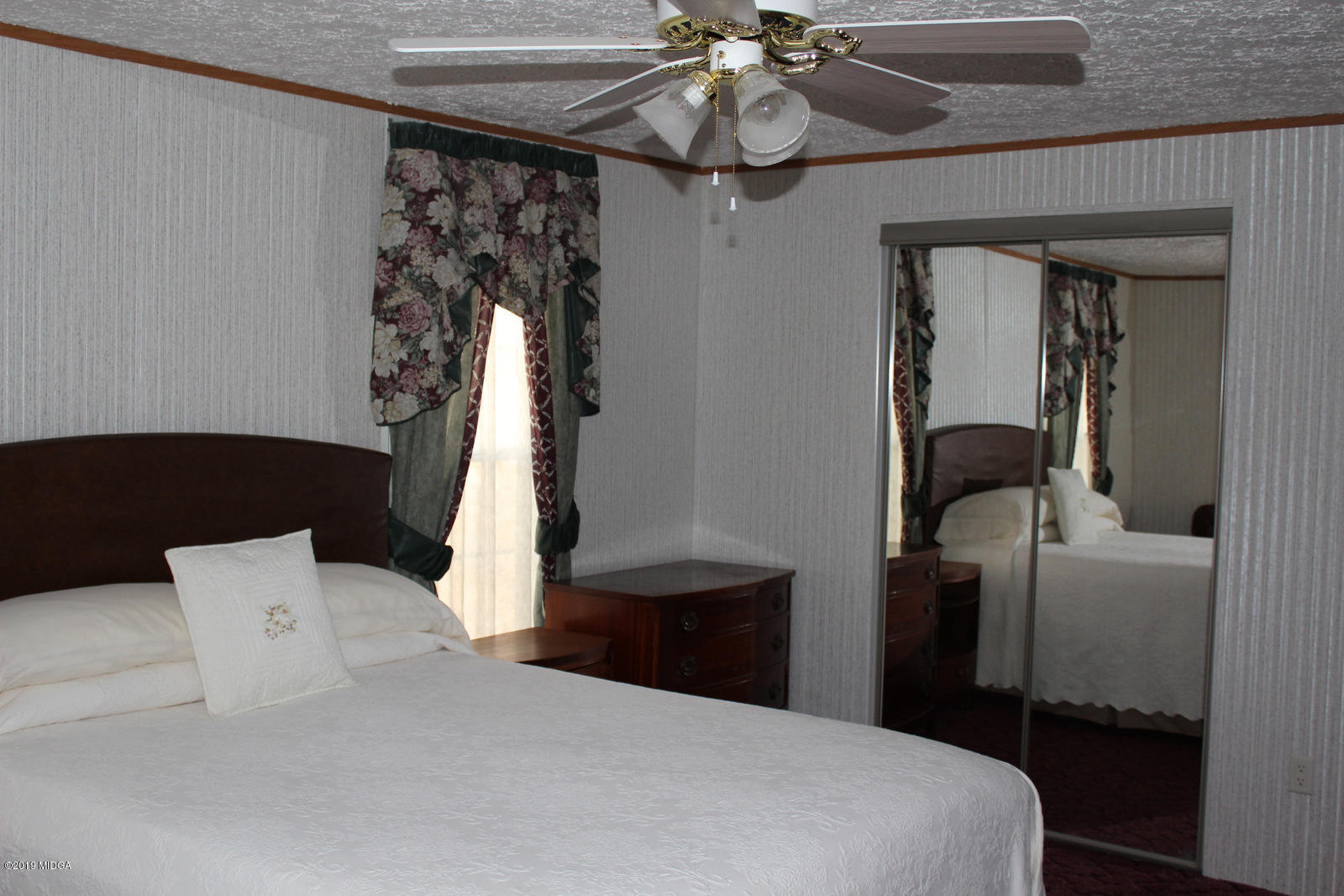 10094 Zebulon Road Forsyth, GA 31029 - Photo 12 of 20 a bedroom with a bed and a chandelier