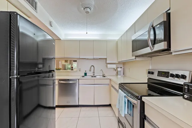 a kitchen with stainless steel appliances a sink stove and refrigerator