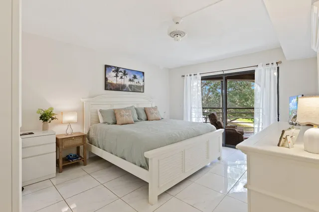 a bedroom with a bed a table and a large window