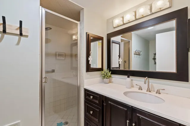 a bathroom with a granite countertop sink and a mirror