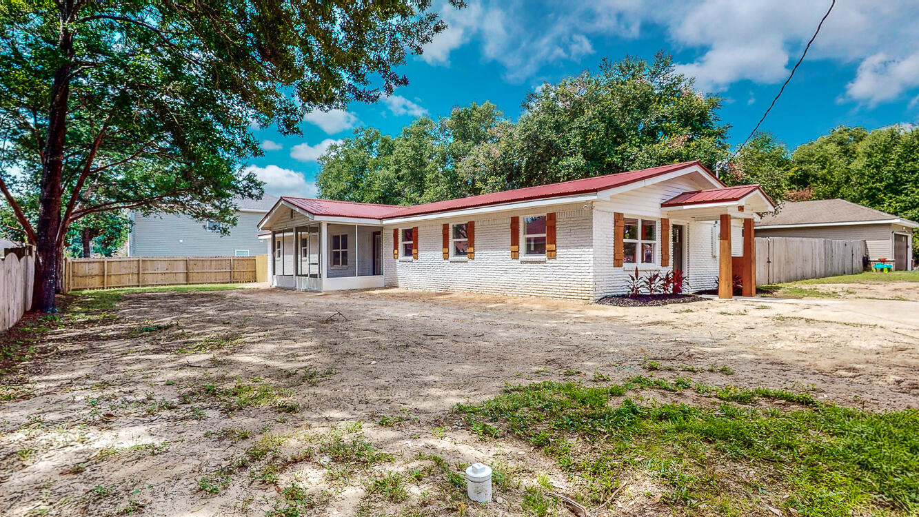 166 Patch Avenue Crestview, FL 32539 - Photo 1 of 48 a front view of a house with a garden