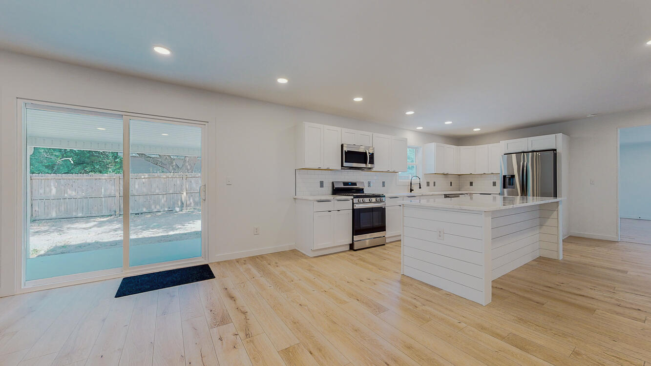 166 Patch Avenue Crestview, FL 32539 - Photo 19 of 48 a kitchen with stainless steel appliances kitchen island granite countertop a refrigerator a sink a stove and white cabinets with wooden floor