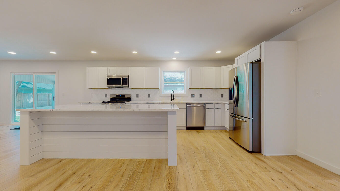 166 Patch Avenue Crestview, FL 32539 - Photo 24 of 48 a large white kitchen with kitchen island a sink a stove a refrigerator and a cabinets
