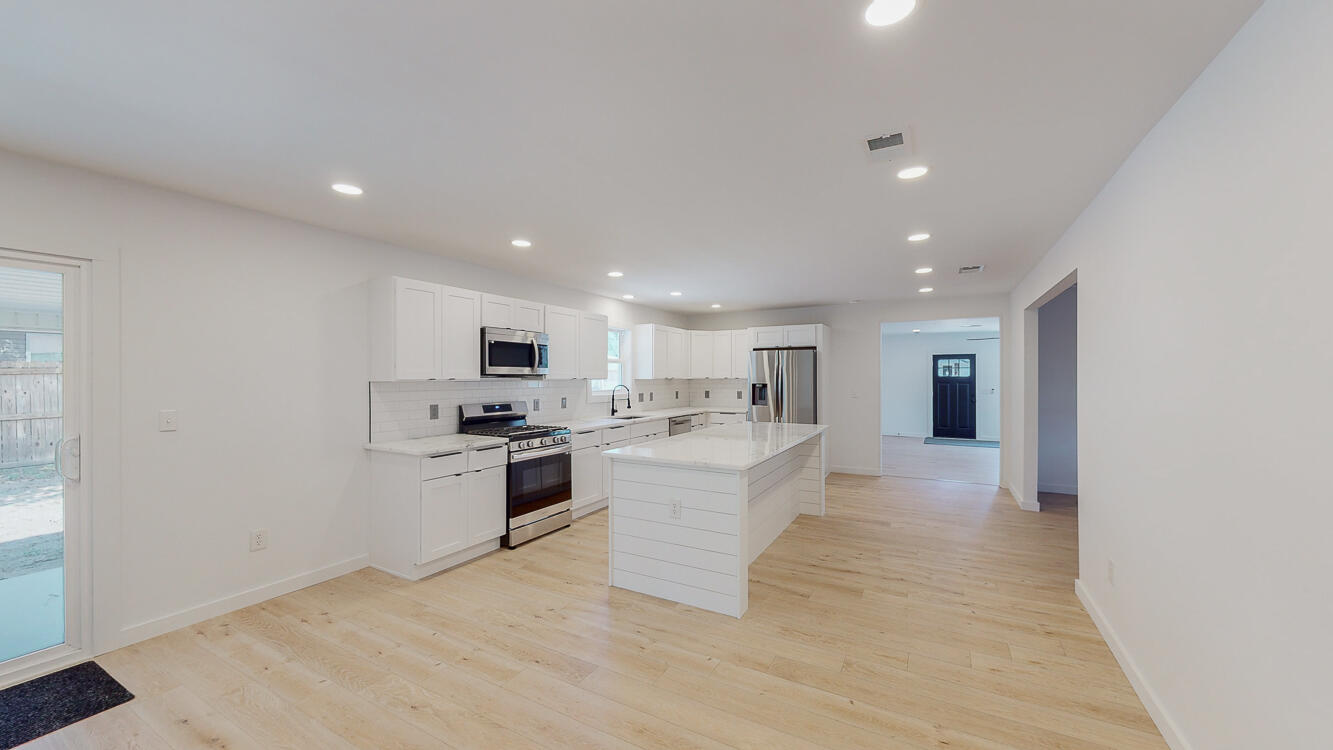 166 Patch Avenue Crestview, FL 32539 - Photo 40 of 48 a large white kitchen with kitchen island a sink a stove a microwave and a refrigerator