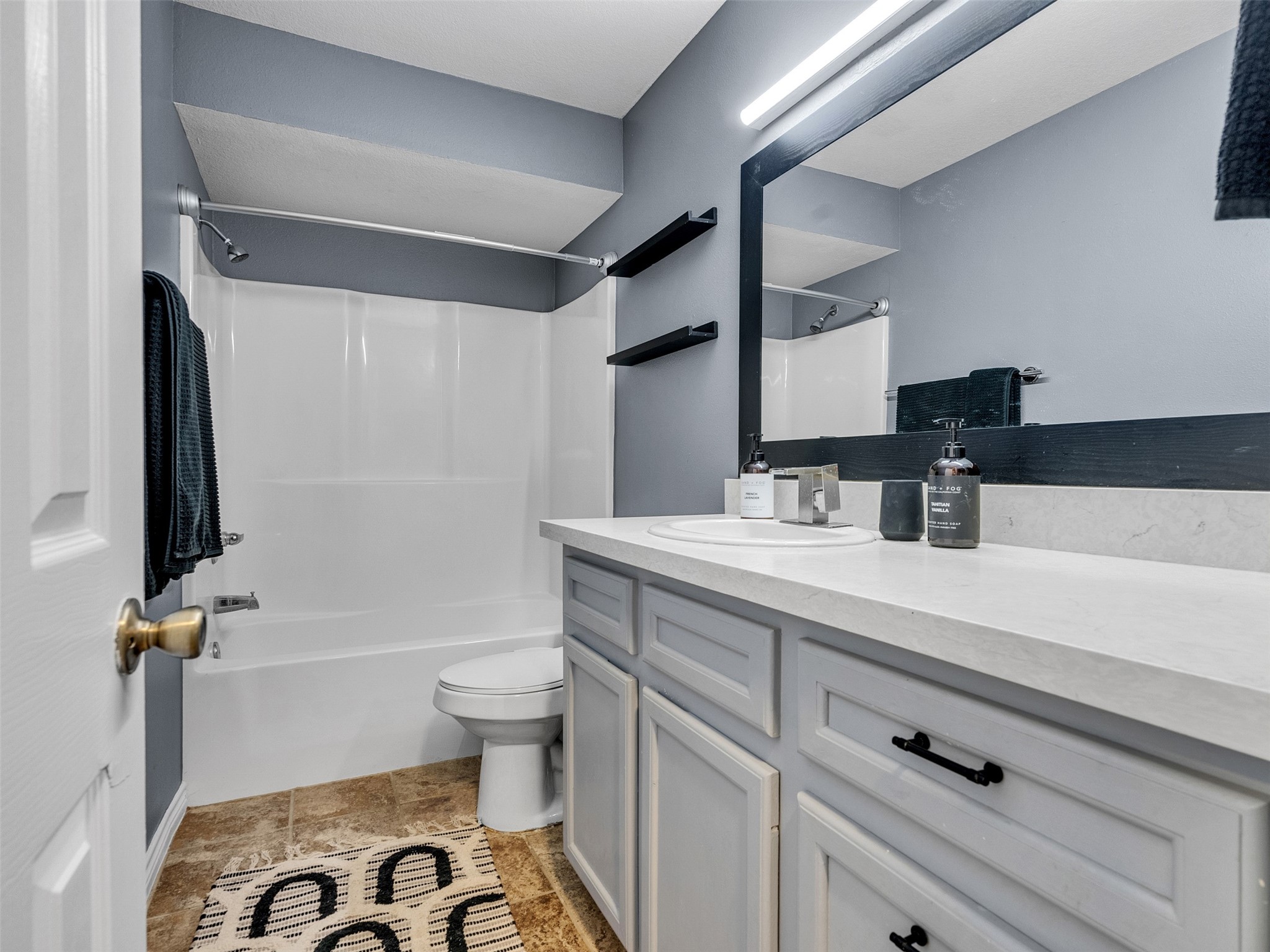 10109 Schaper Road Galveston, TX 77554 - Photo 11 of 33 a bathroom with a sink a toilet a mirror and shower