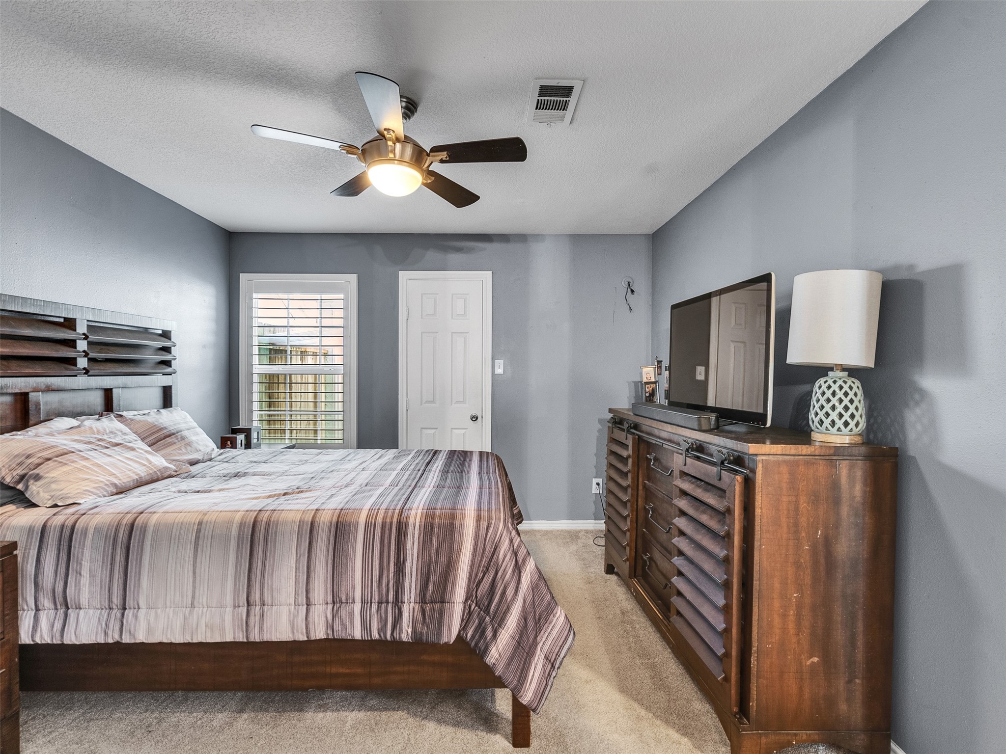 10109 Schaper Road Galveston, TX 77554 - Photo 13 of 33 a bedroom with a bed next to a window with a flat screen tv