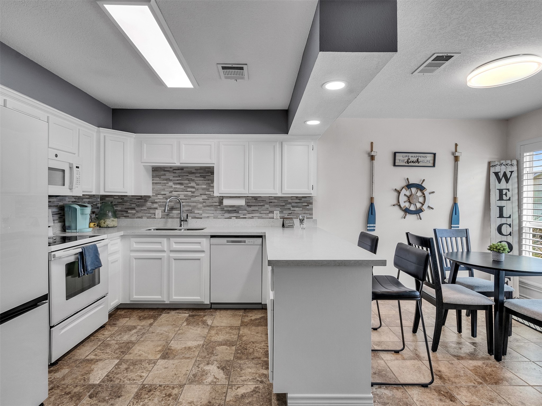 10109 Schaper Road Galveston, TX 77554 - Photo 5 of 33 a kitchen with granite countertop white cabinets and stainless steel appliances