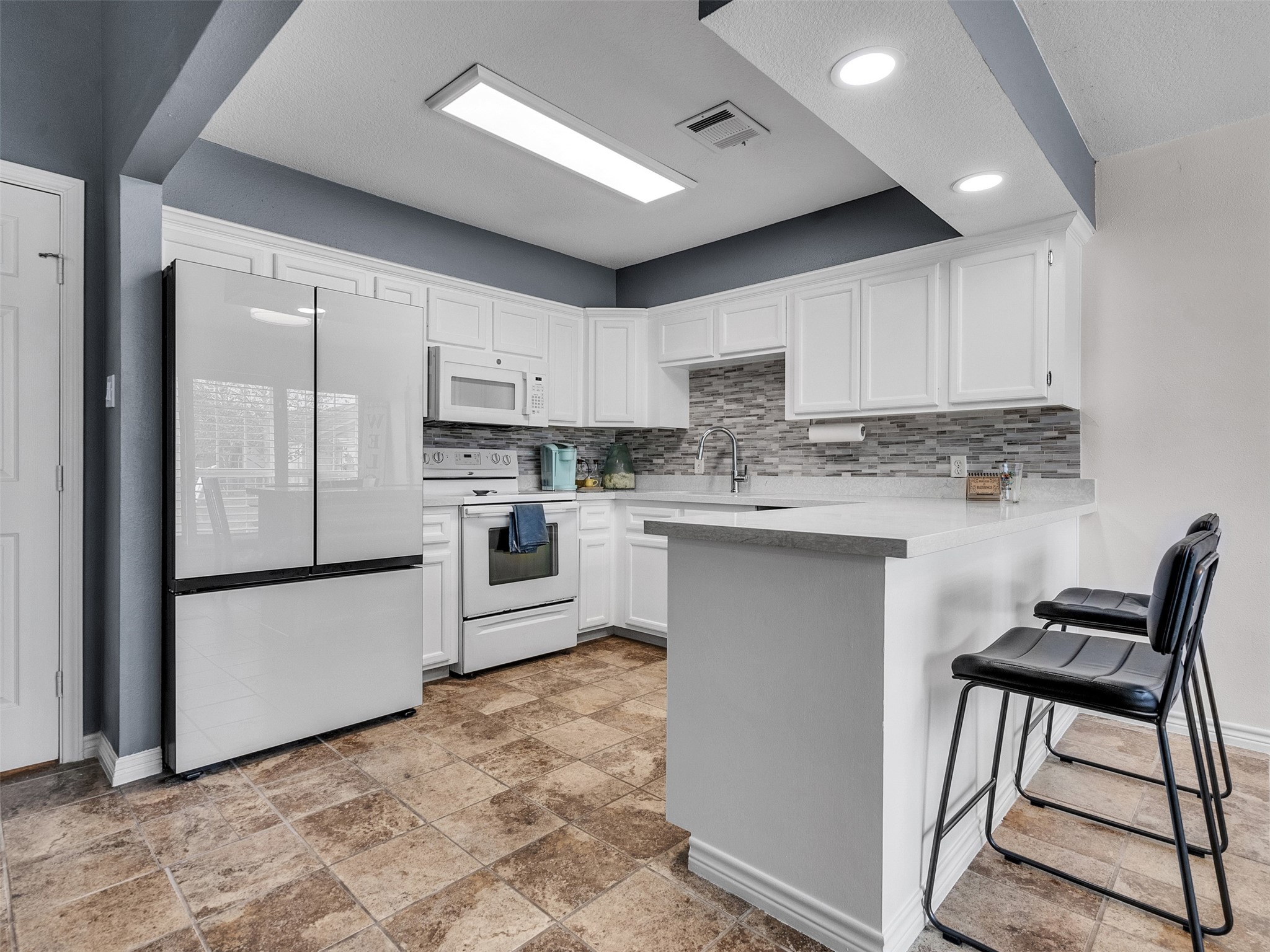 10109 Schaper Road Galveston, TX 77554 - Photo 6 of 33 a kitchen with stainless steel appliances granite countertop a stove a sink a refrigerator and a microwave