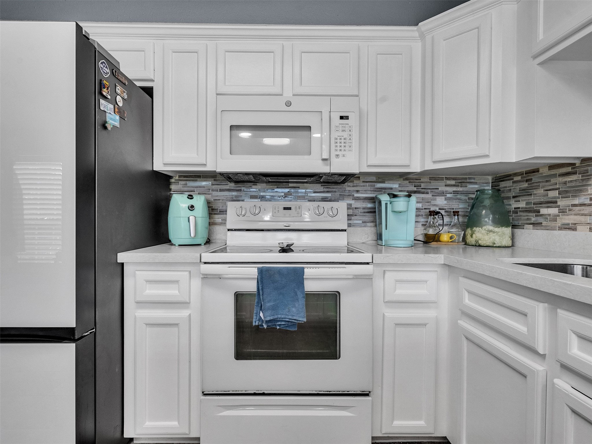 10109 Schaper Road Galveston, TX 77554 - Photo 8 of 33 a kitchen with white cabinets and white appliances