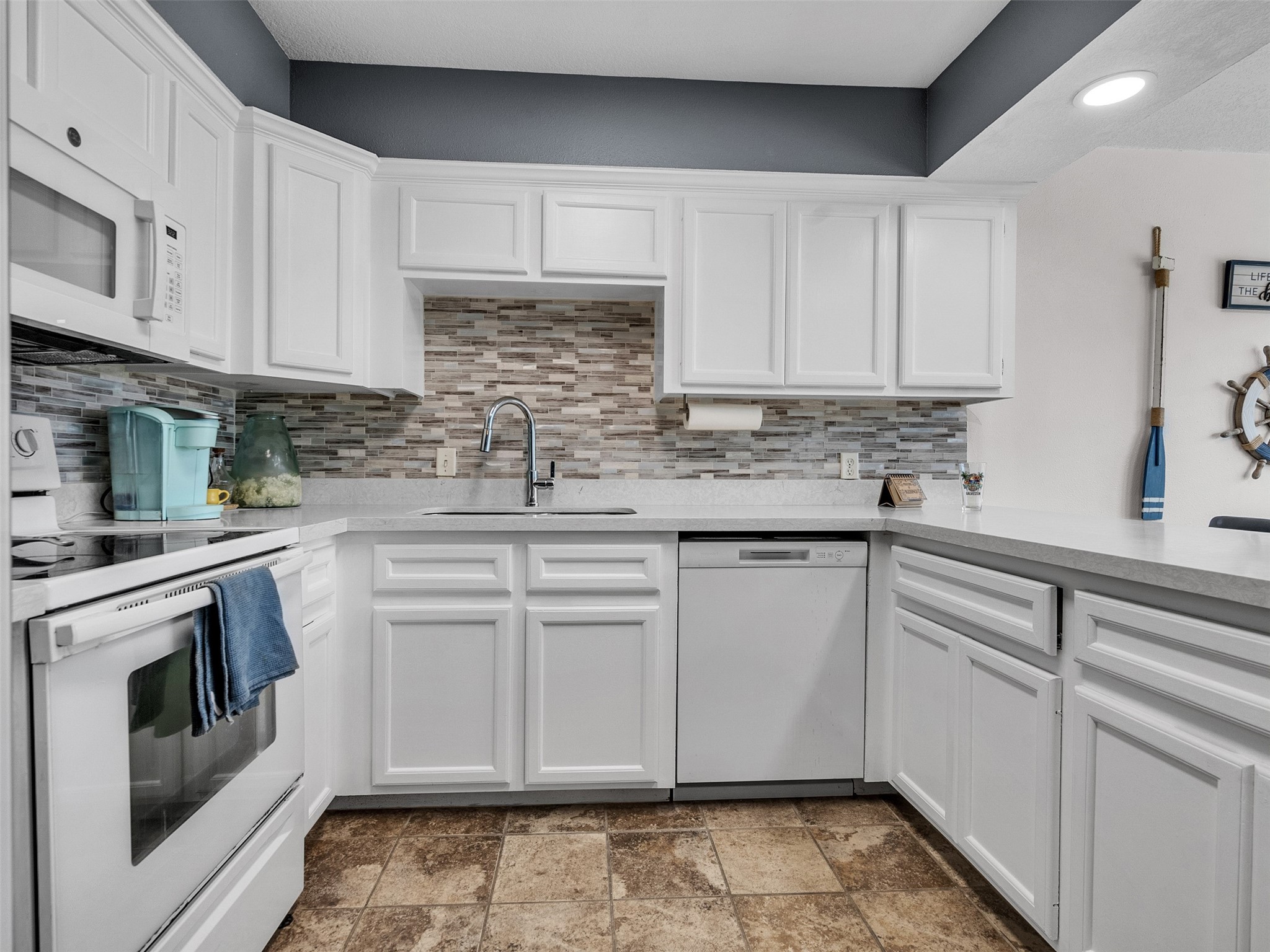 10109 Schaper Road Galveston, TX 77554 - Photo 9 of 33 a kitchen with stainless steel appliances granite countertop a sink stove and cabinets