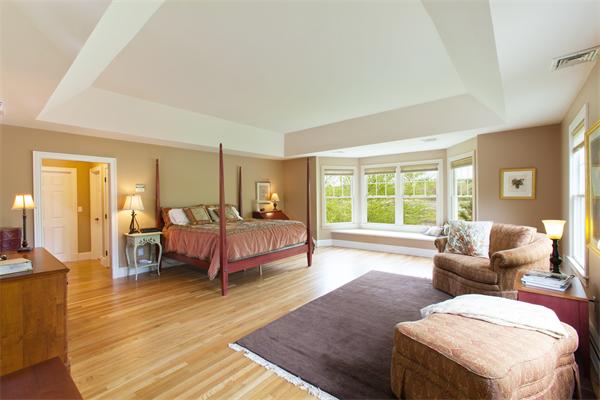 52 MacMillan Drive Concord, MA 01742 - Photo 19 of 23 a spacious bedroom with a bed and wooden floor