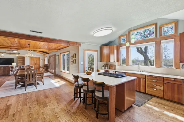 a dining hall with stainless steel appliances granite countertop a stove and a dining table view