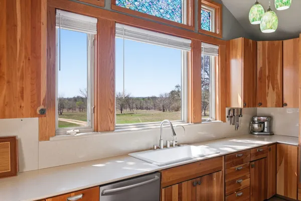 a bathroom with a granite countertop sink and a large window