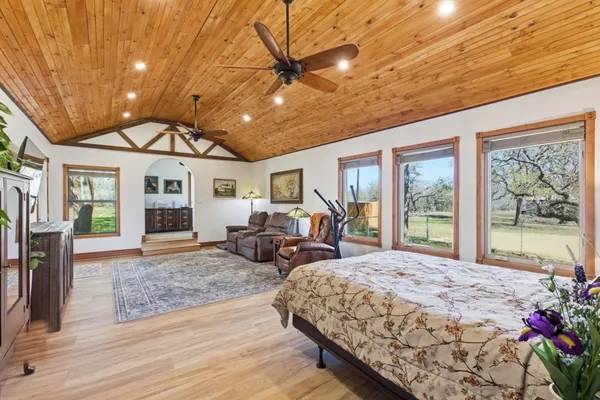 a spacious bedroom with a large bed and a chandelier