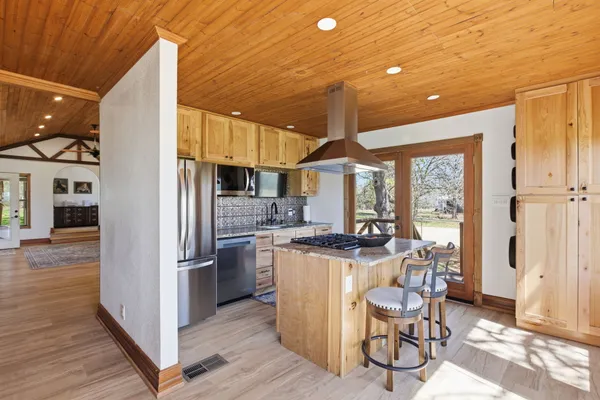 a kitchen with stainless steel appliances granite countertop a refrigerator and a stove top oven