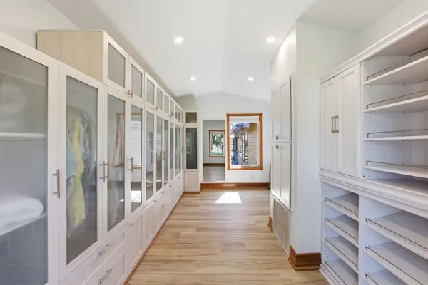 a view of a hallway with wooden floor and windows