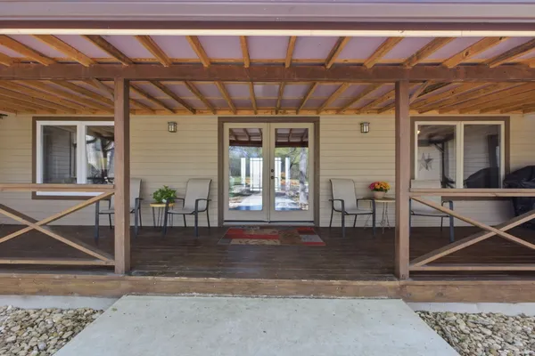 a view of a porch with a table and chairs