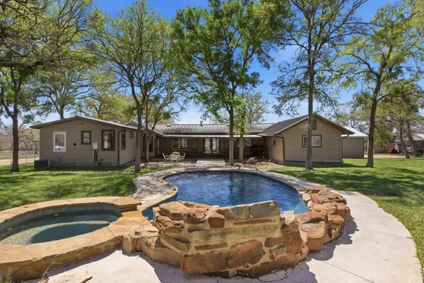 a view of a house with backyard and trees