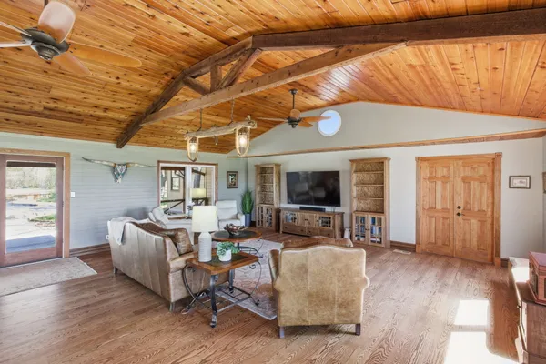 a living room with furniture a flat screen tv and wooden floor